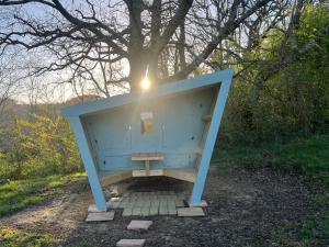 a blue bench sitting on the ground under a tree at Cabane étape in Idrac-Respailles