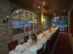 a long dining room with white tables and chairs at Hotel Da Gianni GmbH in Oranienburg +21 photos