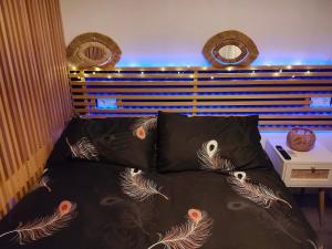 a bed with a black comforter and two pillows at Mabel House Sierra de Gredos in Mijares