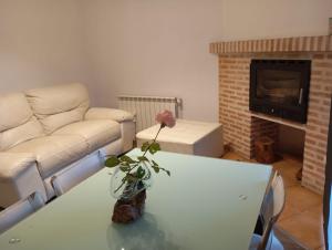 a living room with a couch and a table with a rose at Mabel House Sierra de Gredos in Mijares