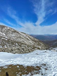 a snow covered hill with a lake in the snow at Mabel House Sierra de Gredos in Mijares