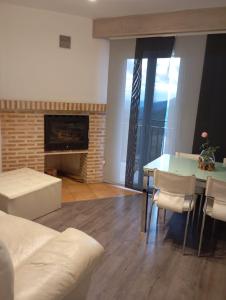 a living room with a table and a fireplace at Mabel House Sierra de Gredos in Mijares