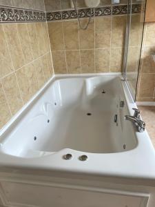 a white bath tub with a faucet in a bathroom at Selsey Home in Selsey +13 photos