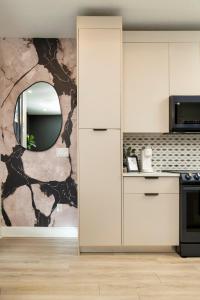 a kitchen with white cabinets and a mirror at 3BR & 3BA Downtown Modern Artsy Home Fully Equipped with Patio in Tampa