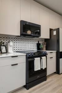 a kitchen with a black stove and a microwave at 3BR & 3BA Downtown Modern Artsy Home Fully Equipped with Patio in Tampa
