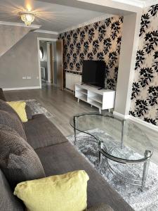 a living room with a couch and a television at Selsey Home in Selsey