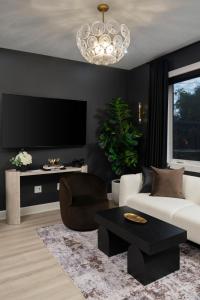 a living room with a white couch and a chandelier at 3BR & 3BA Downtown Modern Artsy Home Fully Equipped with Patio in Tampa