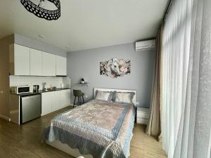 a bedroom with a bed and a small kitchen at Ocean Grace Residence in Batumi