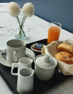 ein Tablett mit Kaffeetassen, ein Teller mit Brot und ein Getränk in der Unterkunft Hotel JORGE CHAVEZ in Trujillo