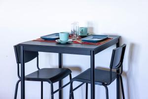 a black table with two chairs and a table with cups at La Venere in Taormina