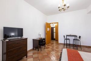 a bedroom with a television and a table with chairs at La Venere in Taormina