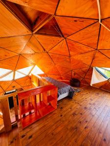 a room with a large wooden ceiling with a bed in it at Domo Del Rio in Los Reartes