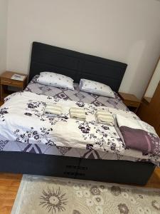 a bed with a black headboard and pillows on it at Apartment near Corvin Castle in Hunedoara