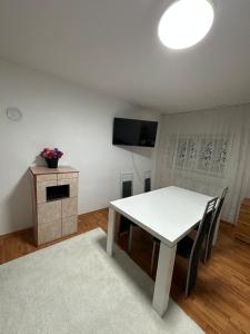 a dining room with a white table and a television at Apartment near Corvin Castle in Hunedoara