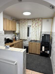 a large kitchen with wooden cabinets and a stove at Apartment near Corvin Castle in Hunedoara