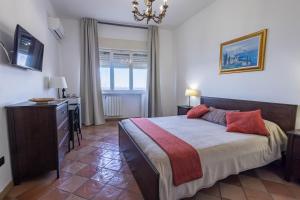 a bedroom with a bed and a dresser and a window at La Venere in Taormina