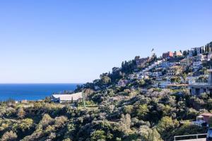 a town on a hill with the ocean in the background at La Venere in Taormina