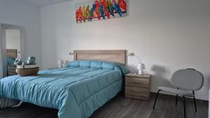 a bedroom with a blue bed and a chair at Casa Cañotas in Val do Dubra