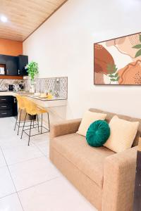 a living room with a couch and a kitchen at Apartamento #10 in Alajuela