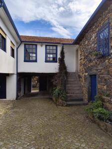 a stone house with a staircase in front of it at Porto Countryside House in Aguiar de Sousa
