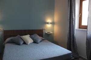 a bedroom with a bed with two pillows and a window at B&B Raggi d'Ischia - nuova gestione 2026 in Casamicciola Terme