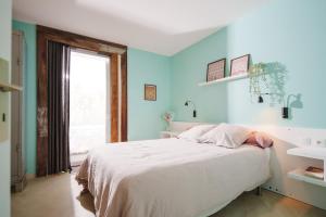 a bedroom with blue walls and a bed with a sink at Les Jardins de Colmar in Herrlisheim-près-Colmar