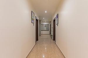 a hallway with white walls and a hallway with doors at Treebo Sloka Residency in Rānchī