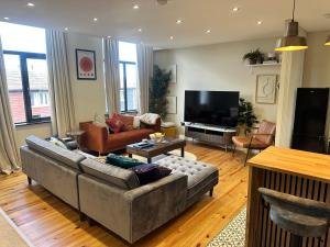 a living room with a couch and a television at STUNNING Apartments in Jarrow, next to A19 & Tyne Tunnel in East Howdon