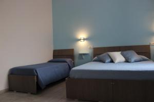 a bedroom with two beds with blue sheets at B&B Raggi d'Ischia - nuova gestione 2026 in Casamicciola Terme