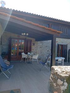 a patio with chairs and a table and a building at CASA DE MADEIRA E PEDRA in Afife