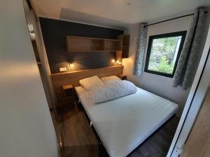 a small bedroom with a white bed and a window at Chez Maya in Étaples