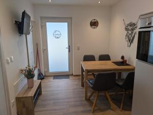 a dining room with a table and chairs and a door at Brunner Alm in Obertaufkirchen