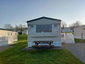 a picnic table in front of a tiny house at Gateway to Cornwall in St Austell