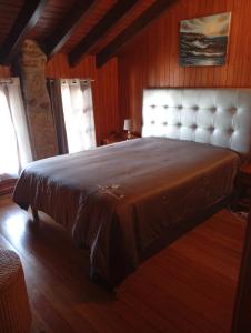 a bedroom with a large bed in a room at CASA DE MADEIRA E PEDRA in Afife