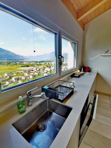 a kitchen with a sink and a large window at Ca Mea - Lake View, Parking, EV in Gordola