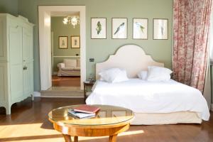 a bedroom with a white bed and a coffee table at Residenza Borgo 27 in Grezzana +47 photos