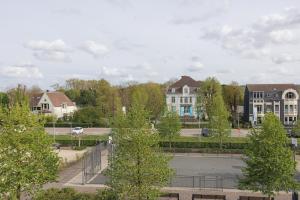 a tennis court in a town with houses and trees at CODAK suite in Kluisbergen