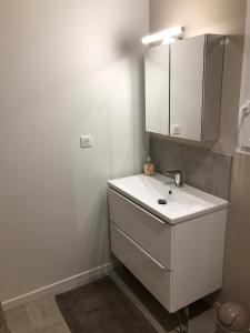 a white bathroom with a sink and a mirror at Villa d Architecte Moderne spa et piscine in Niort +18 photos