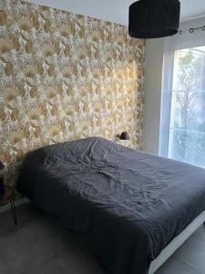 a bed in a bedroom with a wall at Villa d Architecte Moderne spa et piscine in Niort