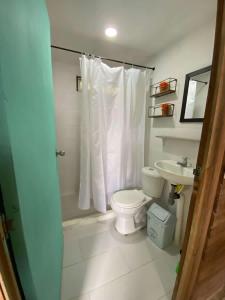 a bathroom with a toilet and a sink at Apartamentos de madera SenSunset Necocli in Necoclí
