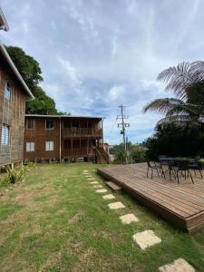 a building with a wooden deck next to a yard at Apartamentos de madera SenSunset Necocli in Necoclí