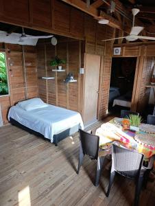 a bedroom with a bed and a table and chairs at Apartamentos de madera SenSunset Necocli in Necoclí +33 photos
