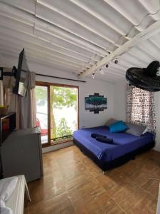a bedroom with a large bed and a large window at Apartamentos de madera SenSunset Necocli in Necoclí