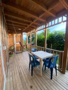 a wooden deck with a table and chairs on it at Apartamentos de madera SenSunset Necocli in Necoclí
