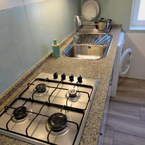 a stove top oven in a kitchen next to a sink at Casa Flamenca in Granada