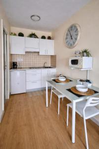 a kitchen with a table and a clock on the wall at Teide & Mar Vistas in Tacoronte