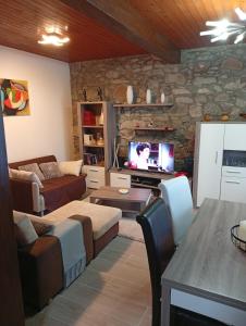 a living room with a couch and a tv at CASA DE MADEIRA E PEDRA in Afife