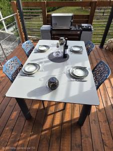 a white table with plates and wine glasses on a deck at Tiny House Annecy in Annecy