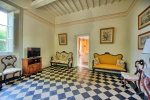 a living room with two chairs and a tv at Villa Fiamma by PosarelliVillas in Piaggiori