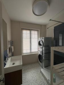 a kitchen with a washer and dryer next to a window at L'Eclat Marin échappée mer in Étretat +15 photos